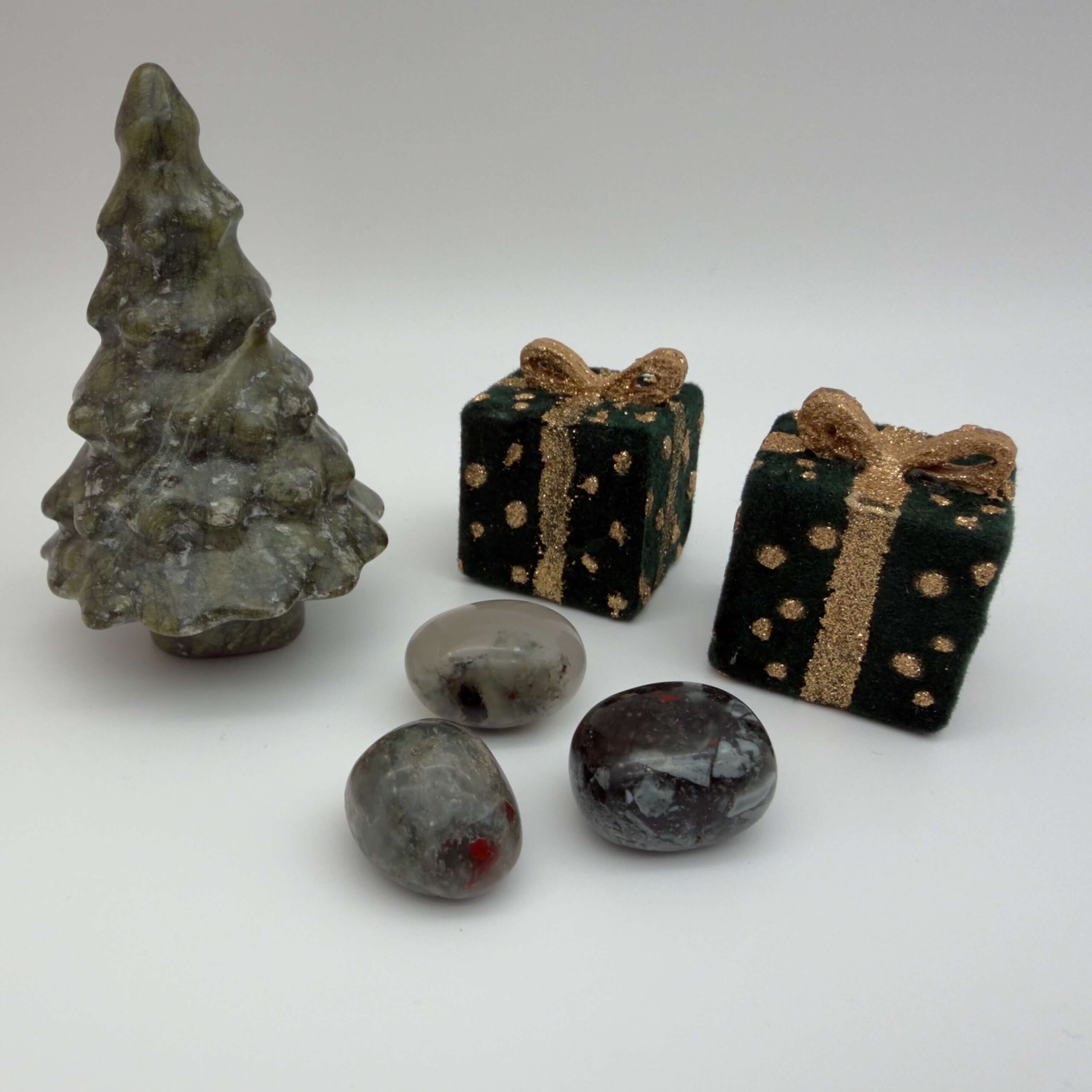 blodsten krystal ved juletræ og gaver på hvid baggrund