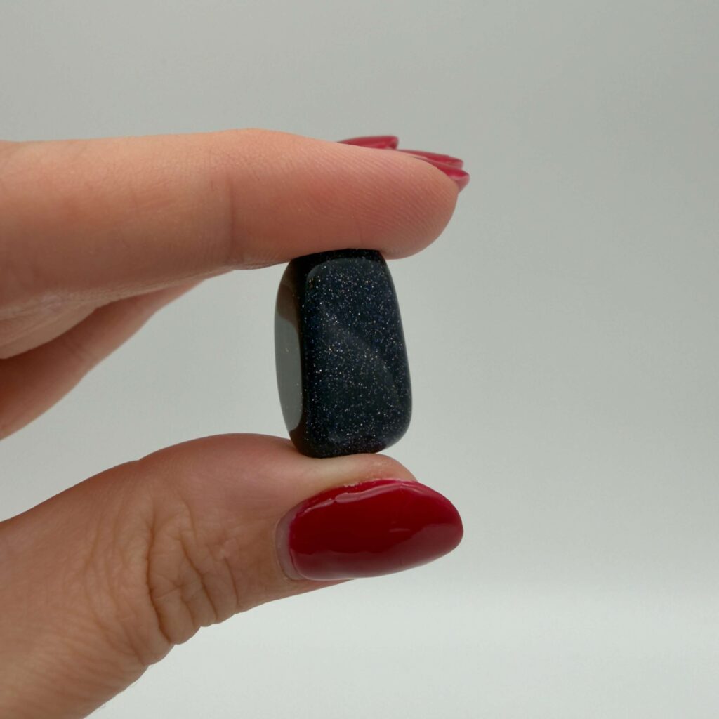 midnightstone krystal i hånd med hvid baggrund