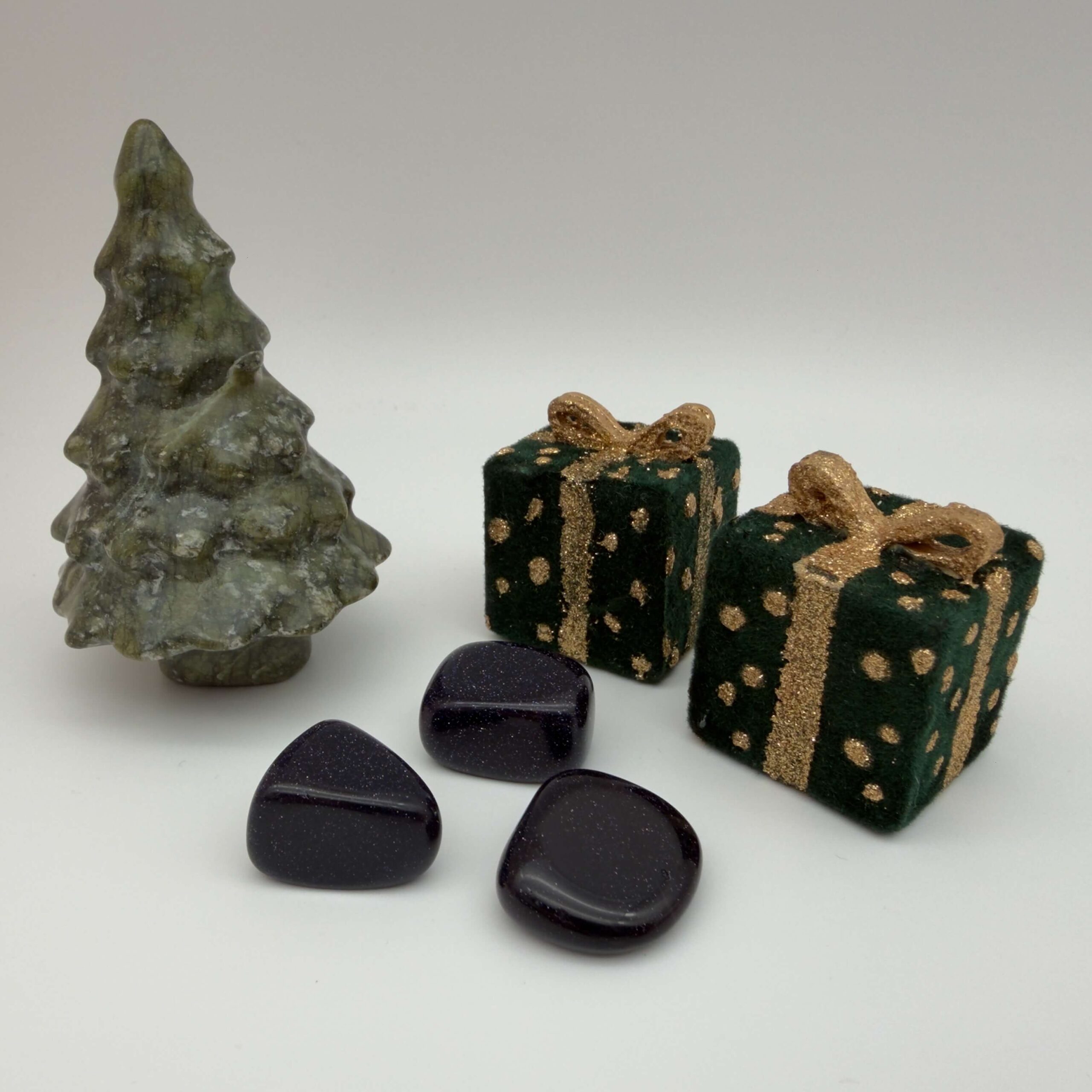 midnightstone krystal ved juletræ og gaver på hvid baggrund