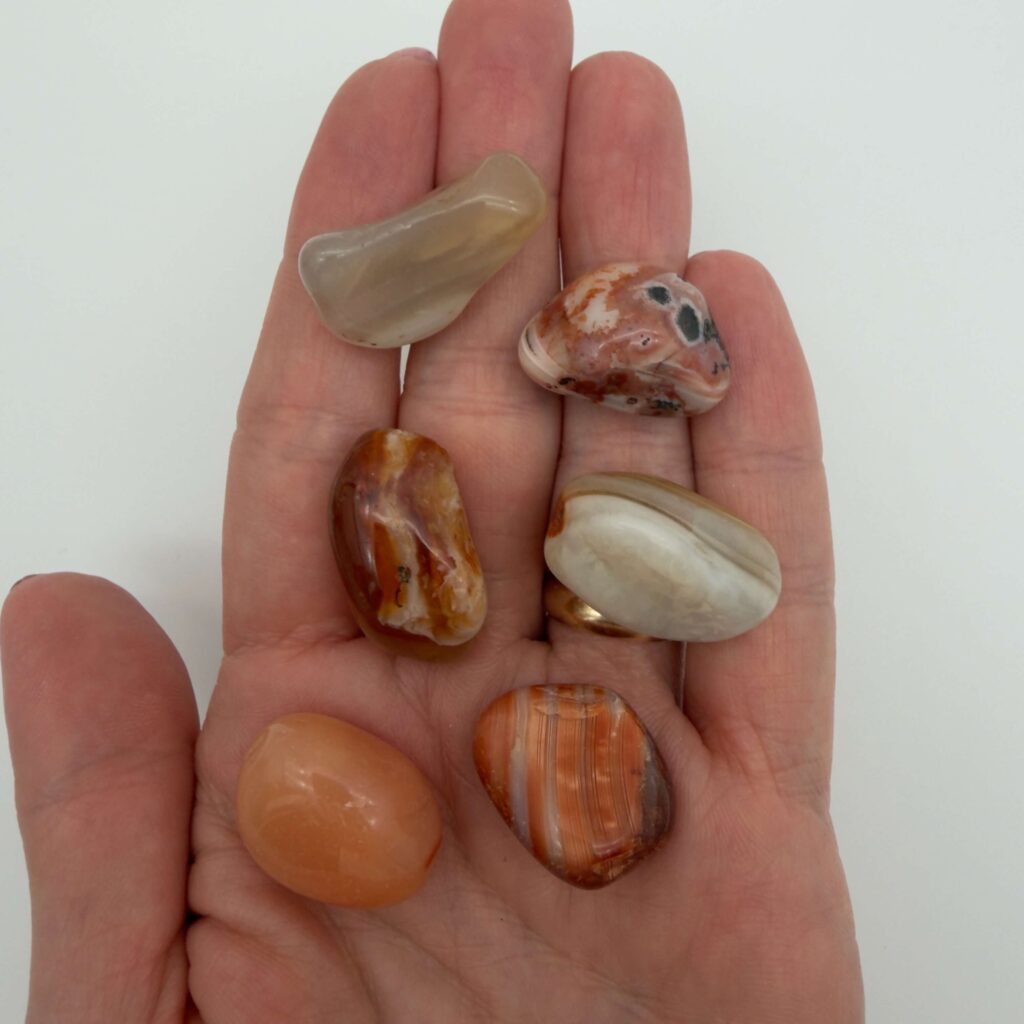 karneol krystal i hånd med hvid baggrund