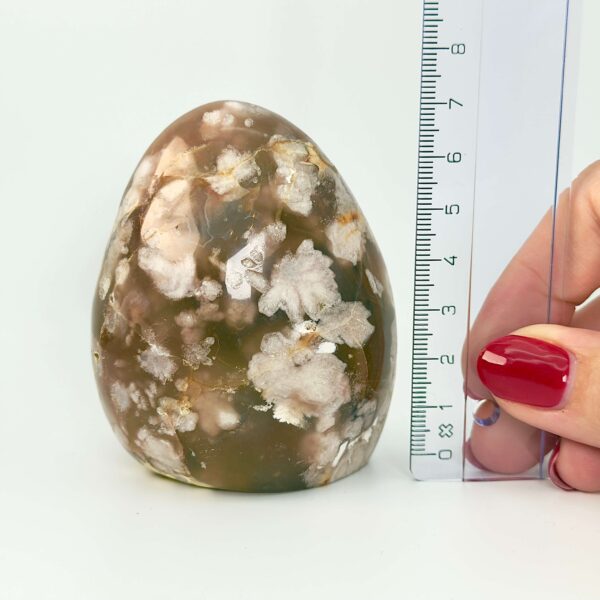 Agat Blomst Freeform Krystal Sten i hånd med lienal på hvid baggrund