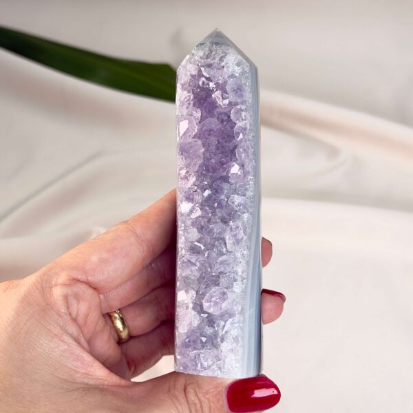 Agat Druzy Tårn Krystal Sten i hånd på hvid og lilla baggrund