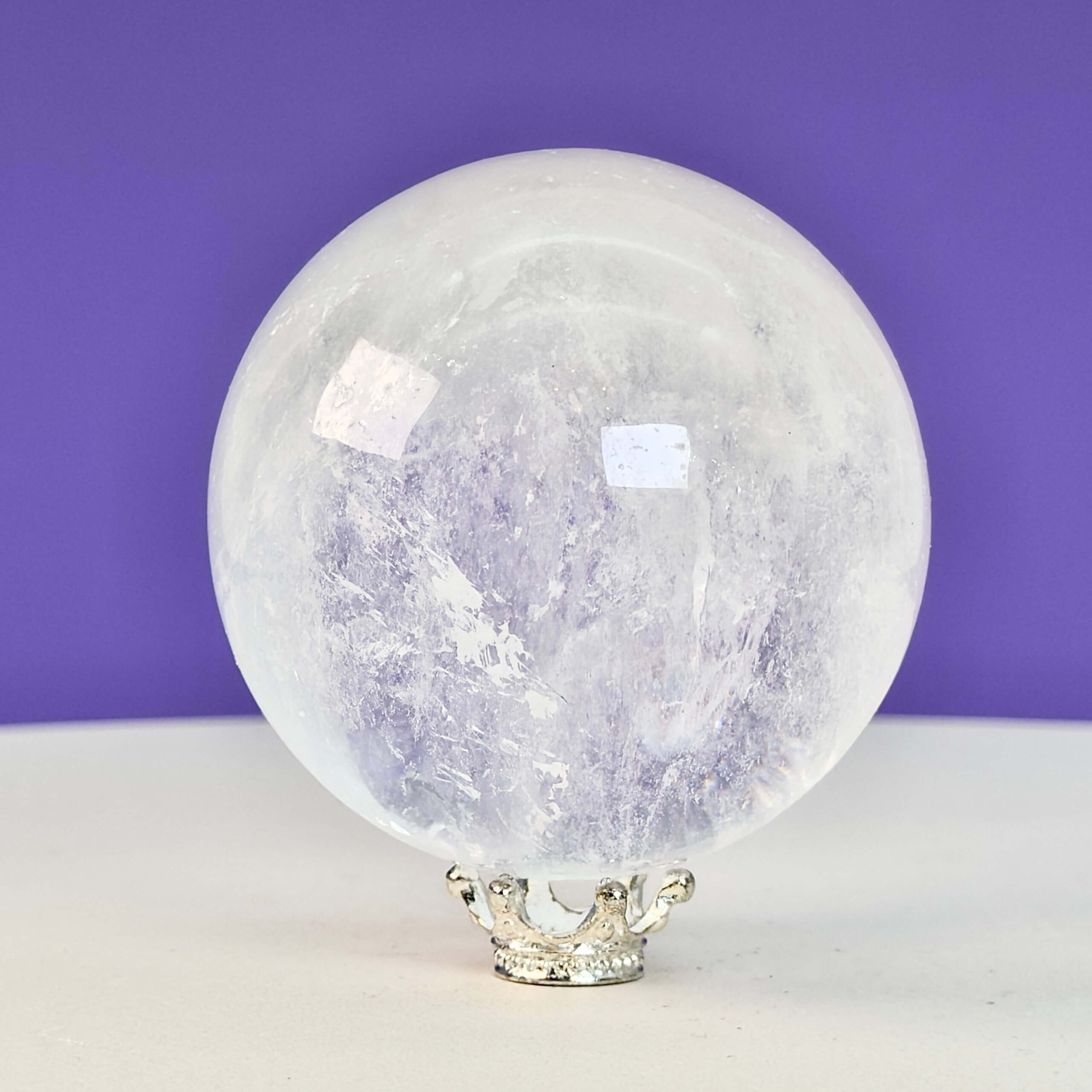 Bjergkrystal Kugle Krystal sten på hvid og lilla baggrund