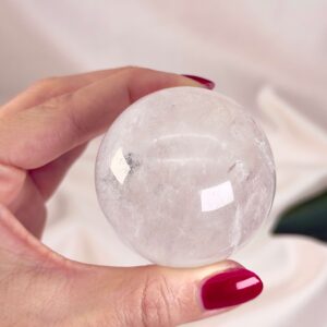 Bjergkrystal Kugle Krystal sten i hånd på hvid baggrund