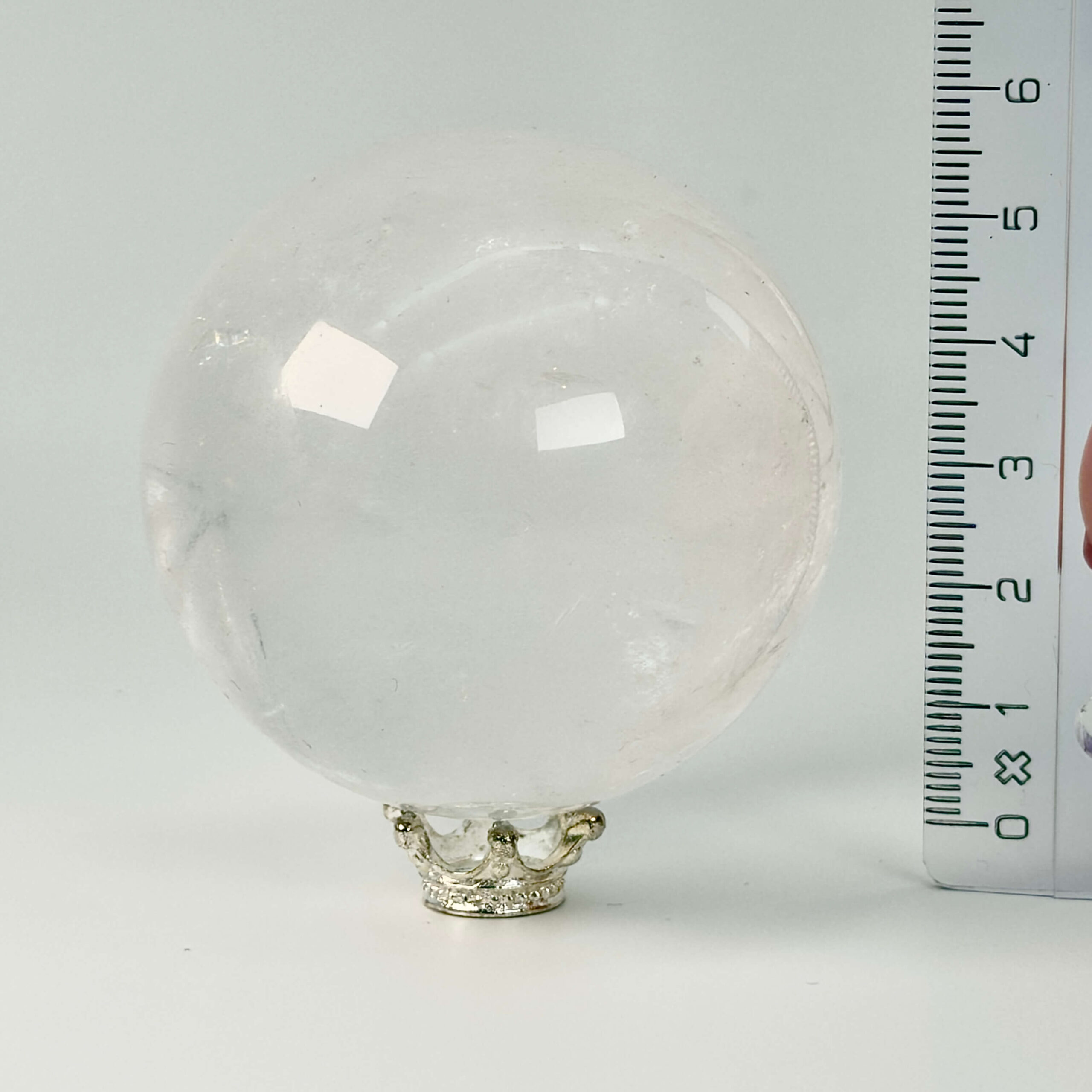 Bjergkrystal Kugle Krystal sten med lineal på hvid baggrund