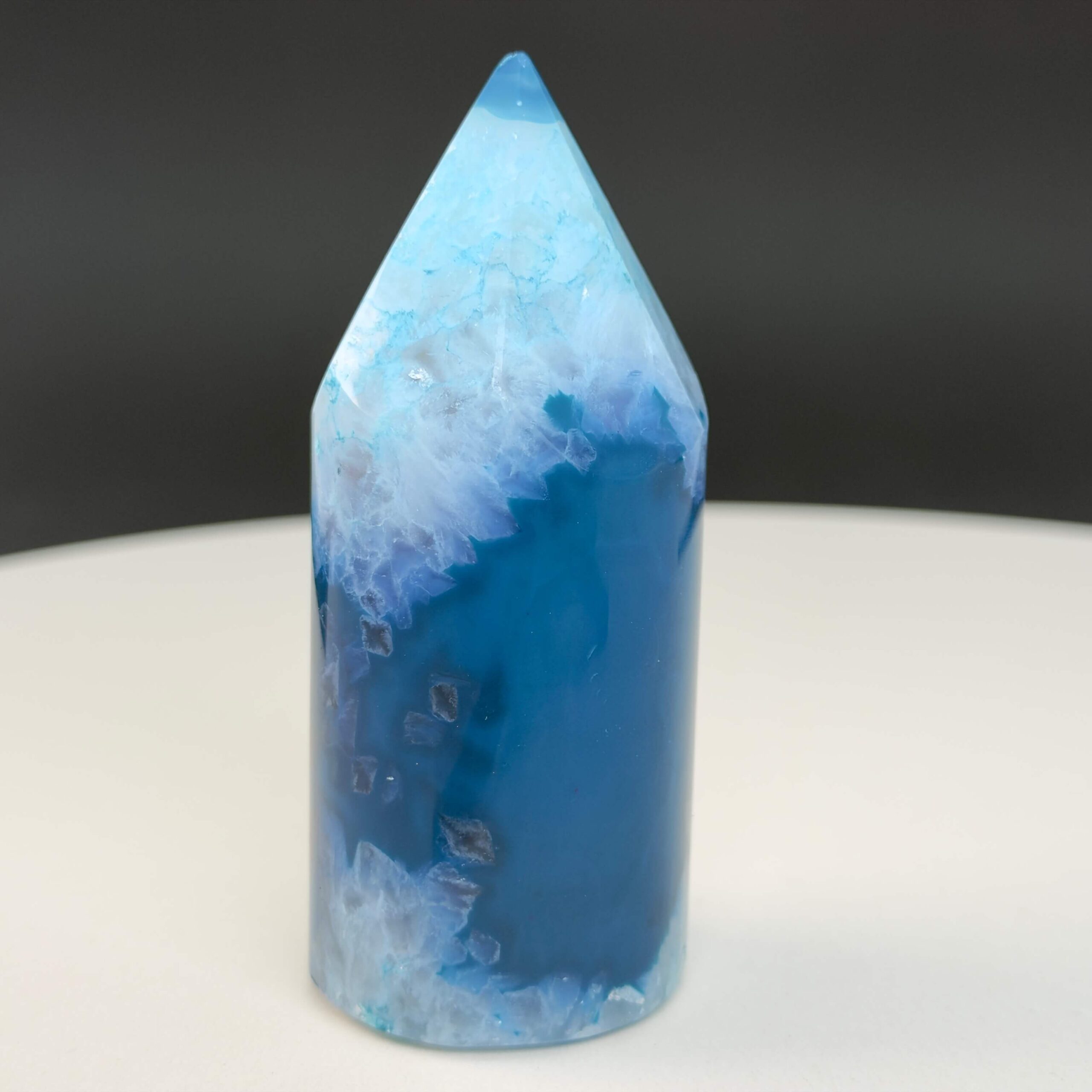 Agat blå krystal spids sten på hvid og sort baggrund