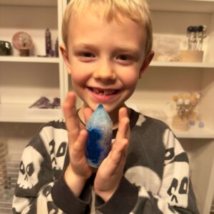 Agat blå krystal spids sten i hånd på dreng Elias