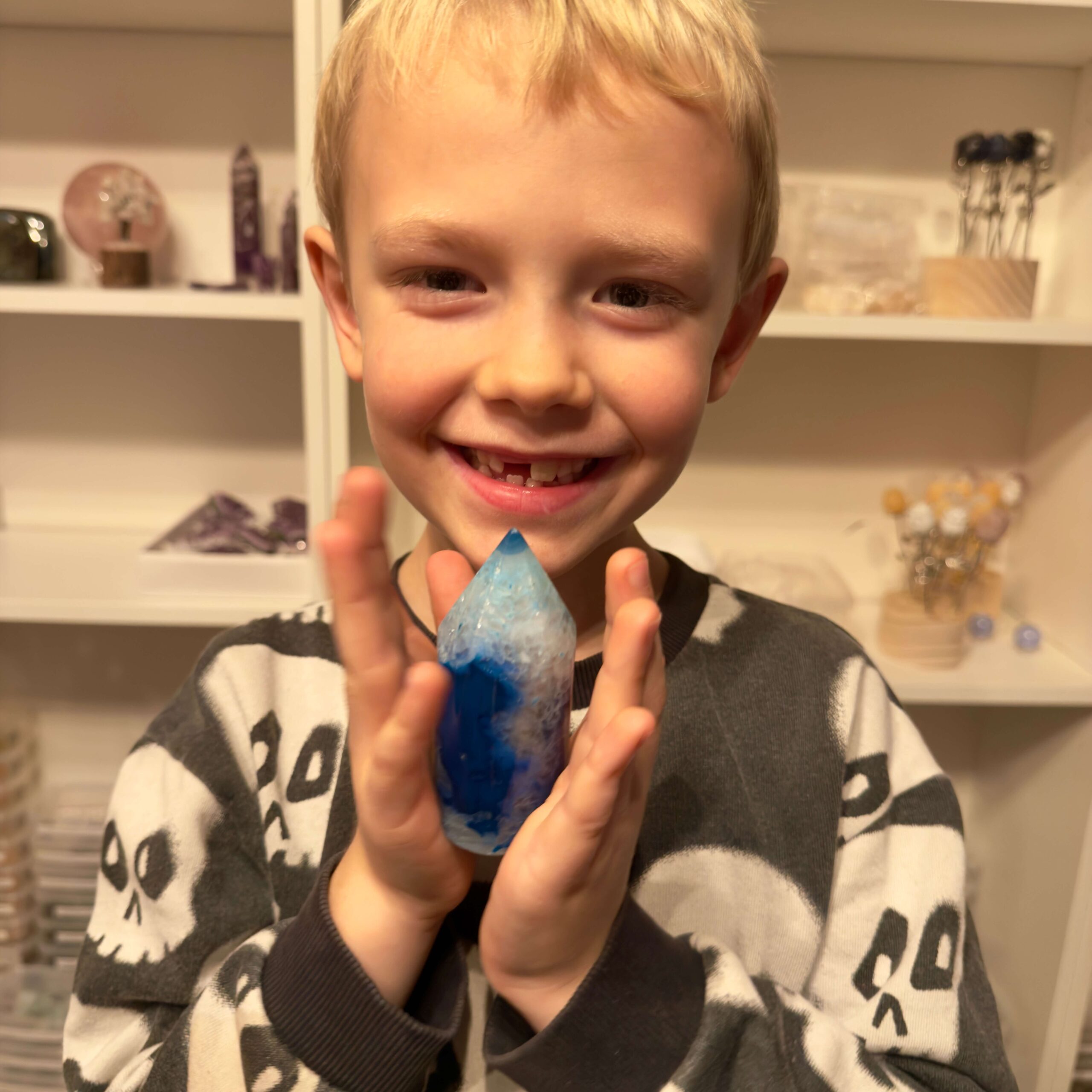 Agat blå krystal spids sten i hånd på dreng Elias