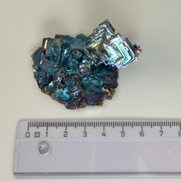 Bismut Vismut krystal rå med hvid baggrund og lineal