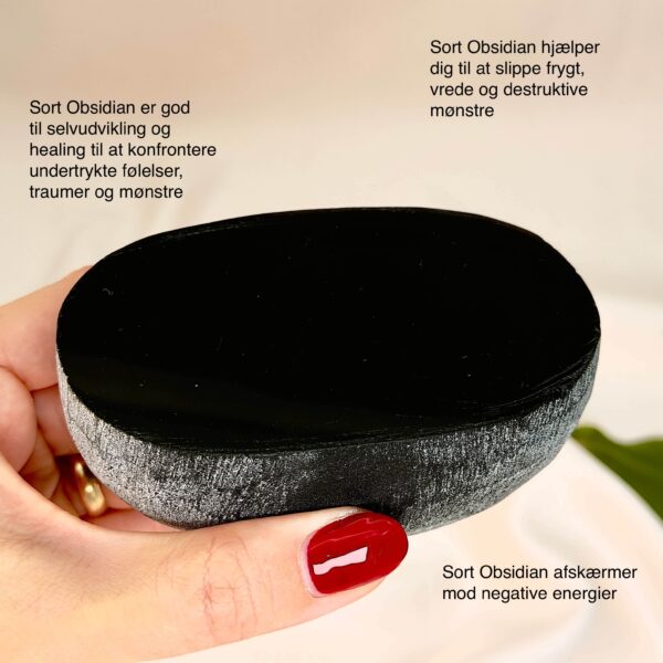 Sort Obsidian Flodsten Freeform krystal sten i hånd på hvid baggrund med tags