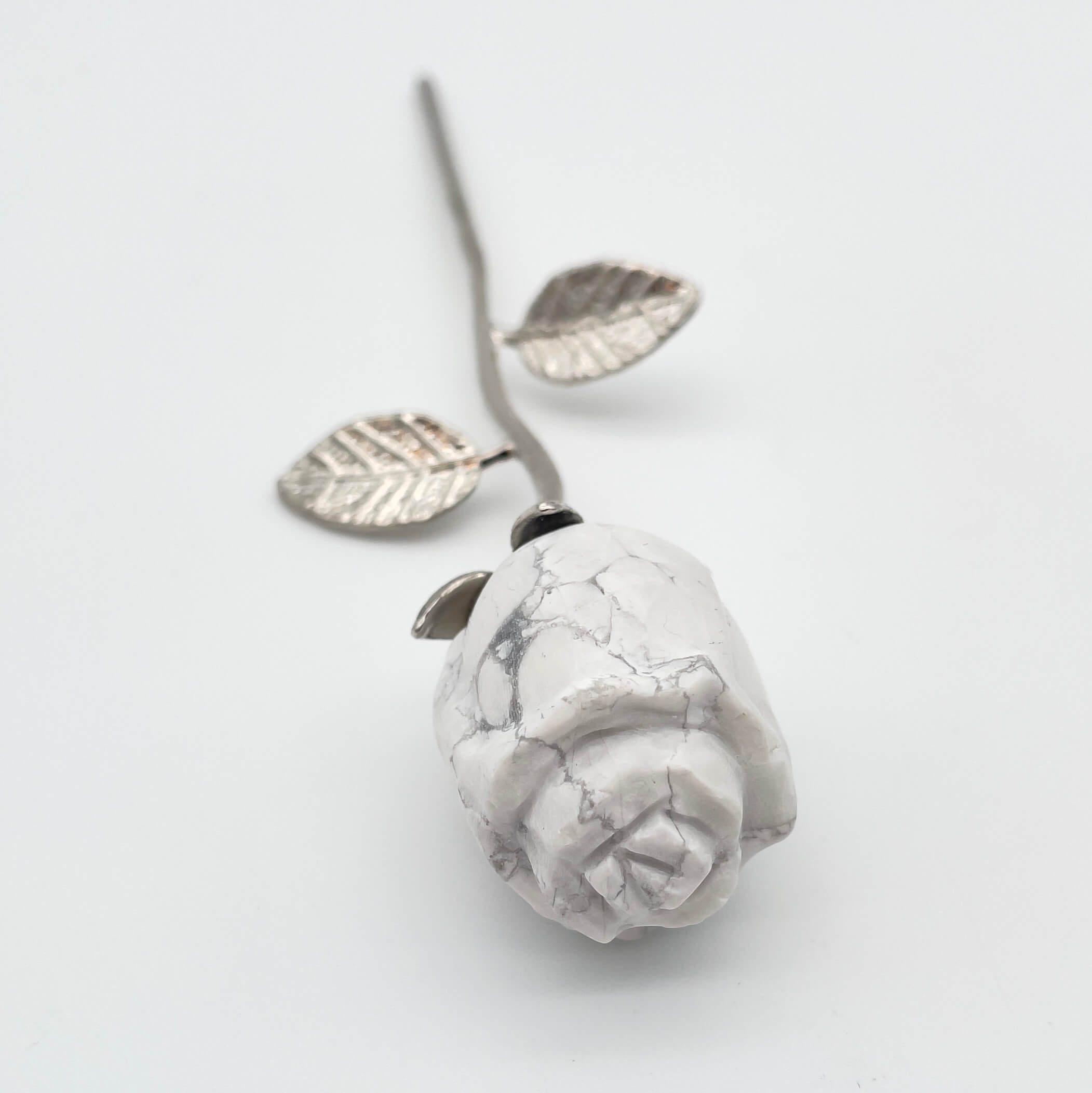 Howlit Rose med sølvfarvet stilk krystal sten med sølv stilk på hvid baggrund