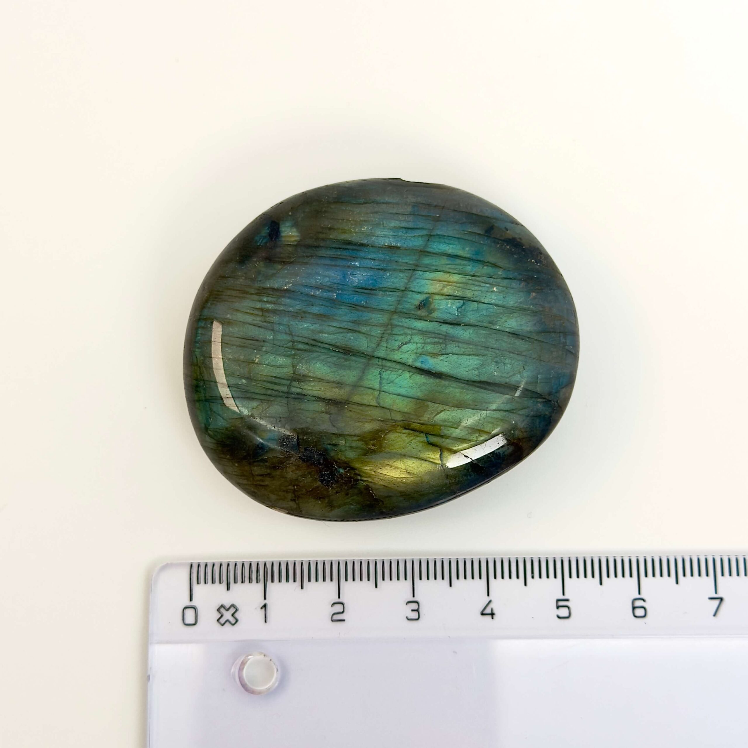 Labradorit Håndsten Krystal sten med lineal på hvid baggrund