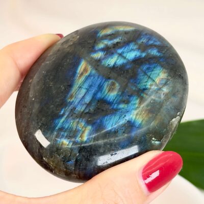 Labradorit Håndsten Krystal sten i hånd på hvid baggrund