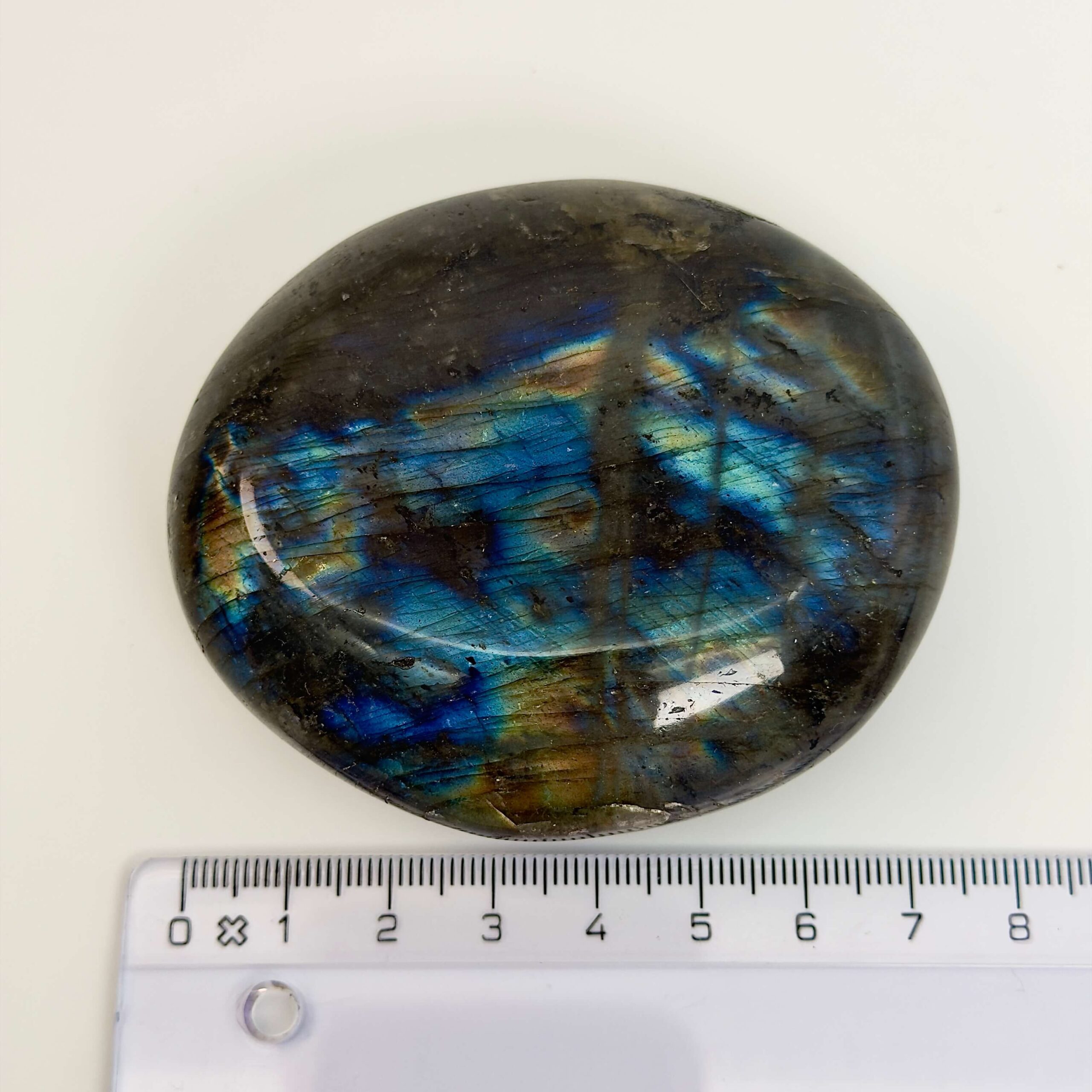 Labradorit Håndsten Krystal sten med lineal på hvid baggrund