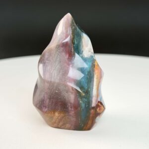 Jaspis Polychrom Freeform Flamme krystal sten på hvid og sort baggrund