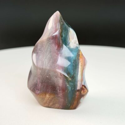 Jaspis Polychrom Freeform Flamme krystal sten på hvid og sort baggrund