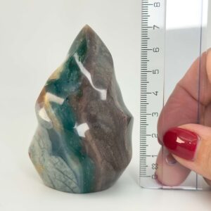 Jaspis Polychrom Freeform Flamme krystal sten med lineal i hånd på hvid baggrund