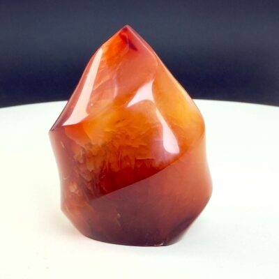 Karneol Freeform Flamme krystal sten på hvid og sort baggrund