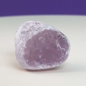 Rosakvarts Flodsten Freeform krystal sten på hvid og lilla baggrund