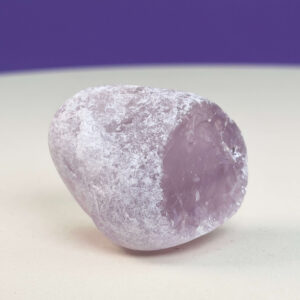 Rosakvarts Flodsten Freeform krystal sten på hvid og lilla baggrund