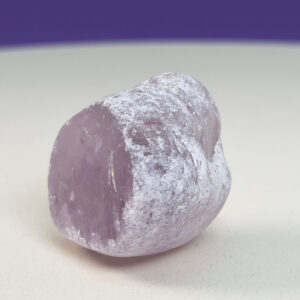 Rosakvarts Flodsten Freeform krystal sten på hvid og lilla baggrund