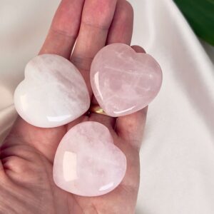 Rosakvarts Hjerte krystal sten på hånd på hvid baggrund