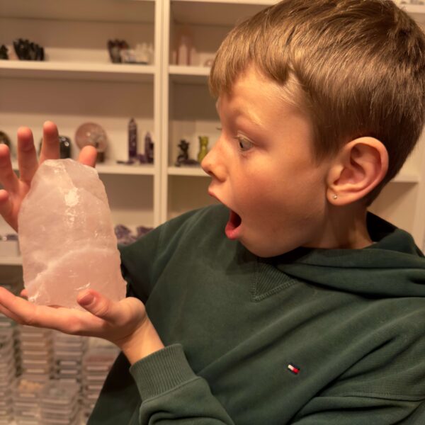 Rosakvarts Rå klynge krystal sten i hånd på dreng Markus