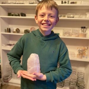 Rosakvarts Rå klynge krystal sten i hånd på dreng Markus