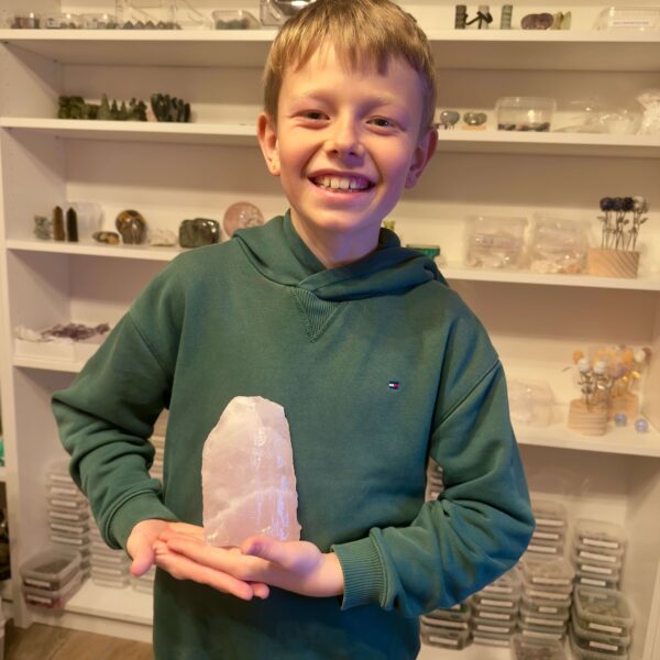 Rosakvarts Rå klynge krystal sten i hånd på dreng Markus