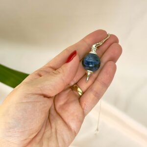 Sodalit Pendul Krystal Sten med kæde i hånd på hvid baggrund