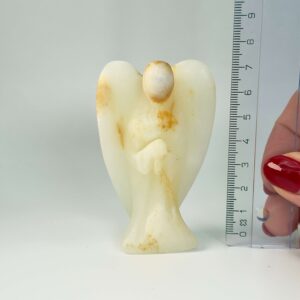 Pakistani Onyx Tårn krystal sten i hånd med lineal på hvid baggrund