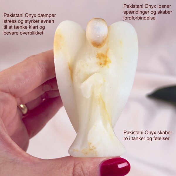 Pakistani Onyx Tårn krystal sten i hånd på hvid baggrund med tags