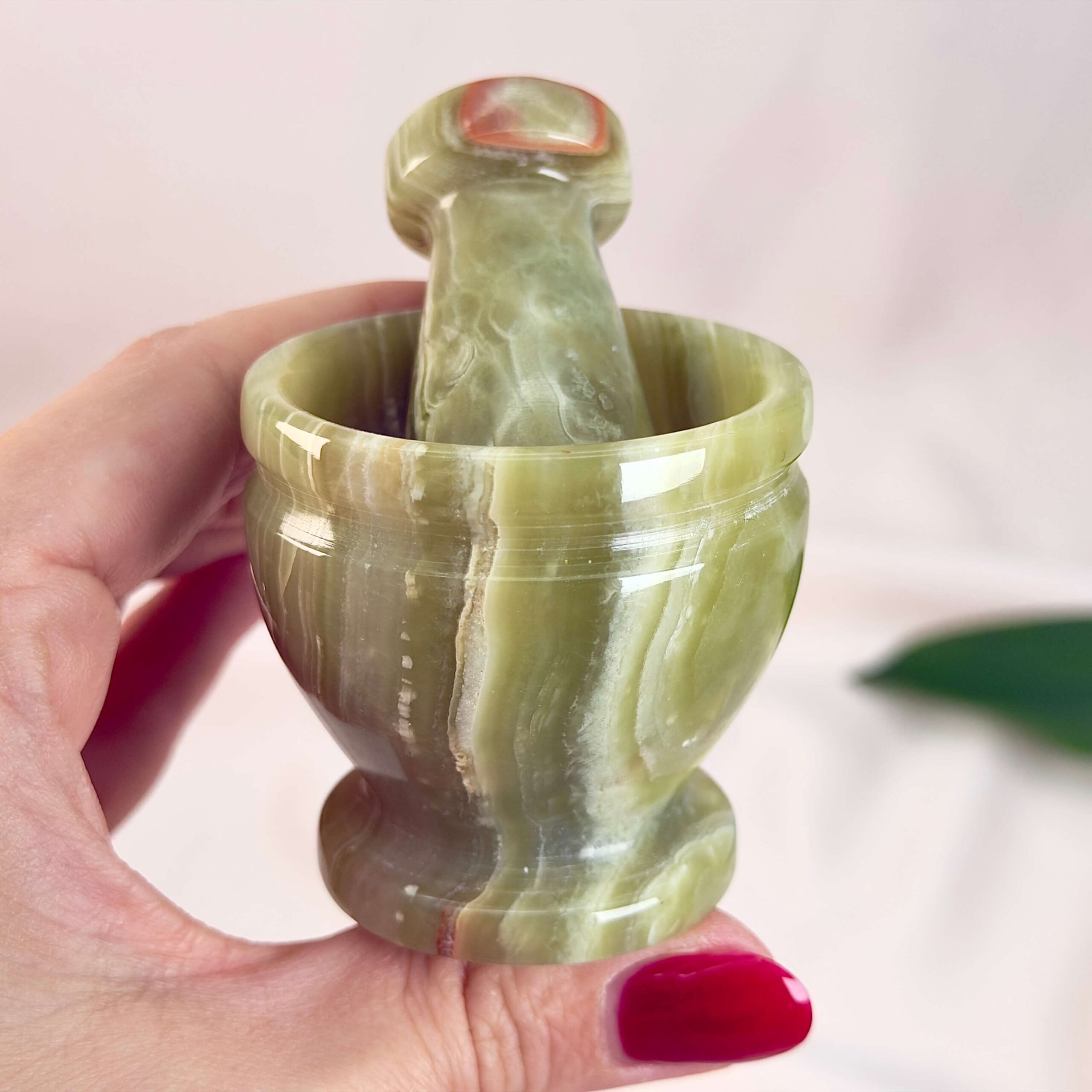 Pakistani Onyx Morter krystal sten i hånd på hvid baggrund