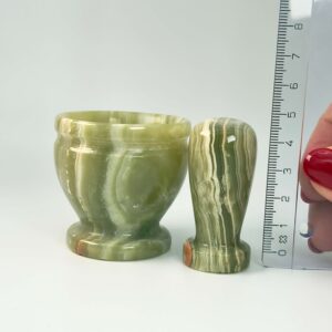 Pakistani Onyx Morter krystal sten i hånd med lineal på hvid baggrund