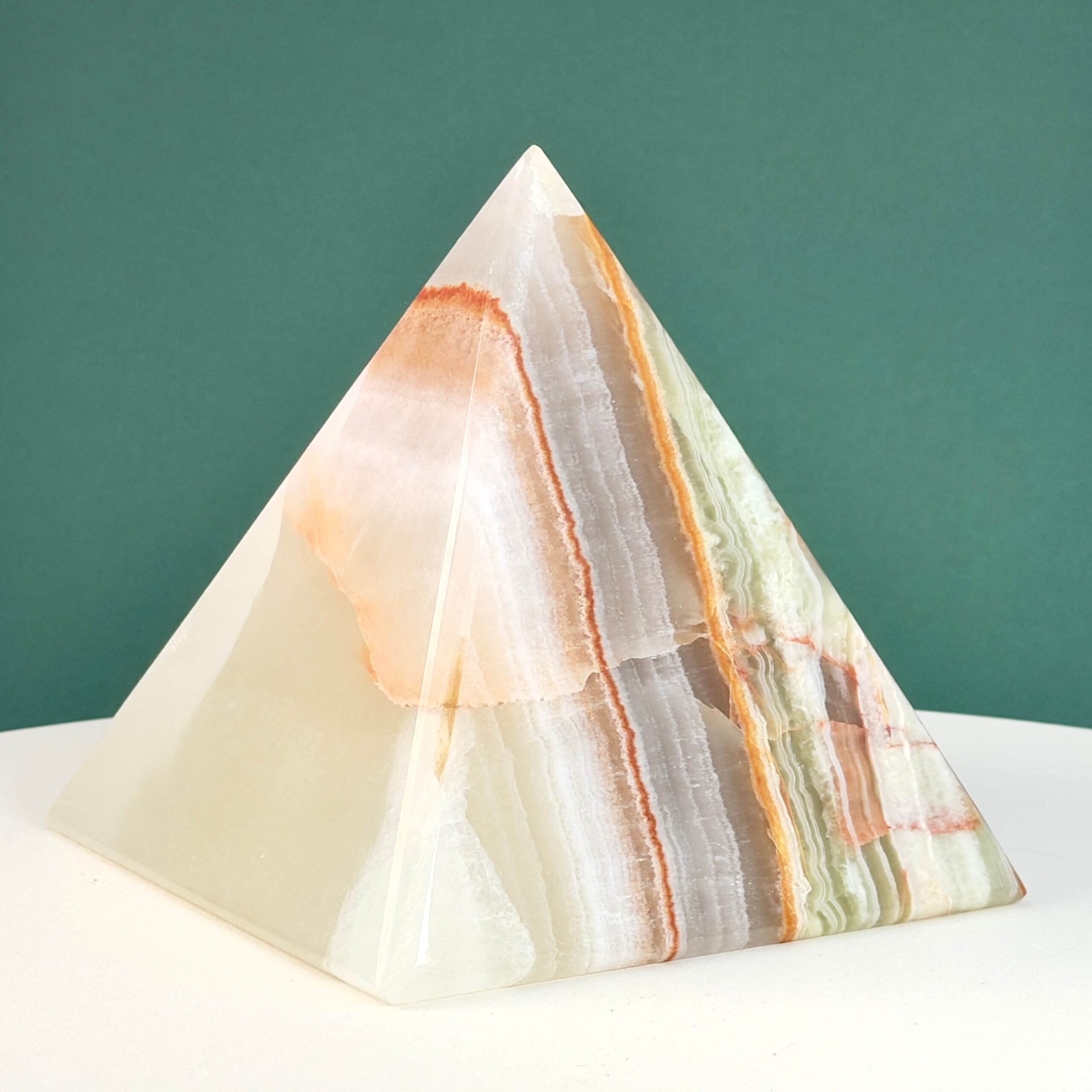 Pakistani Onyx Pyramide krystal sten på hvid og grøn baggrund