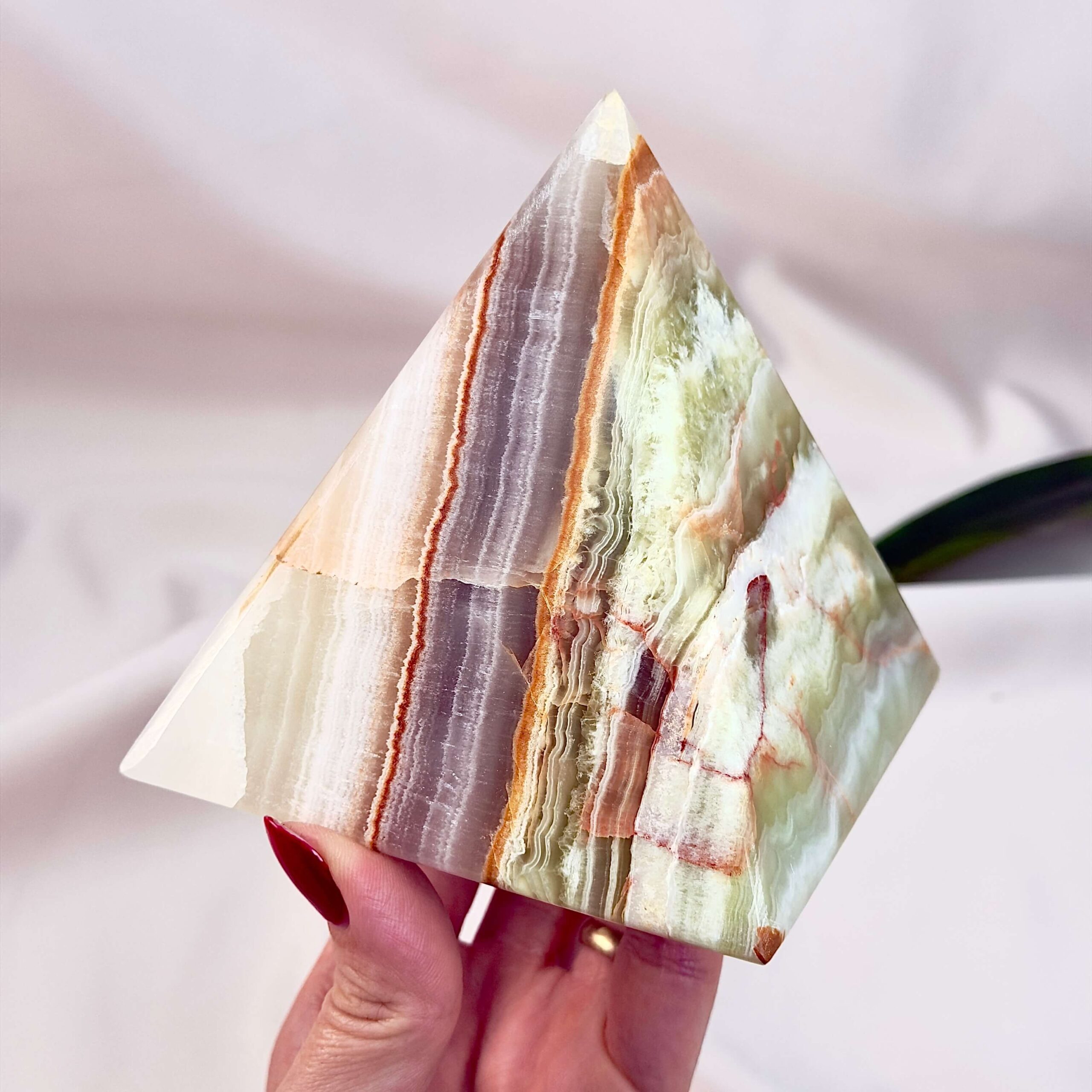 Pakistani Onyx Pyramide krystal sten i hånd på hvid baggrund