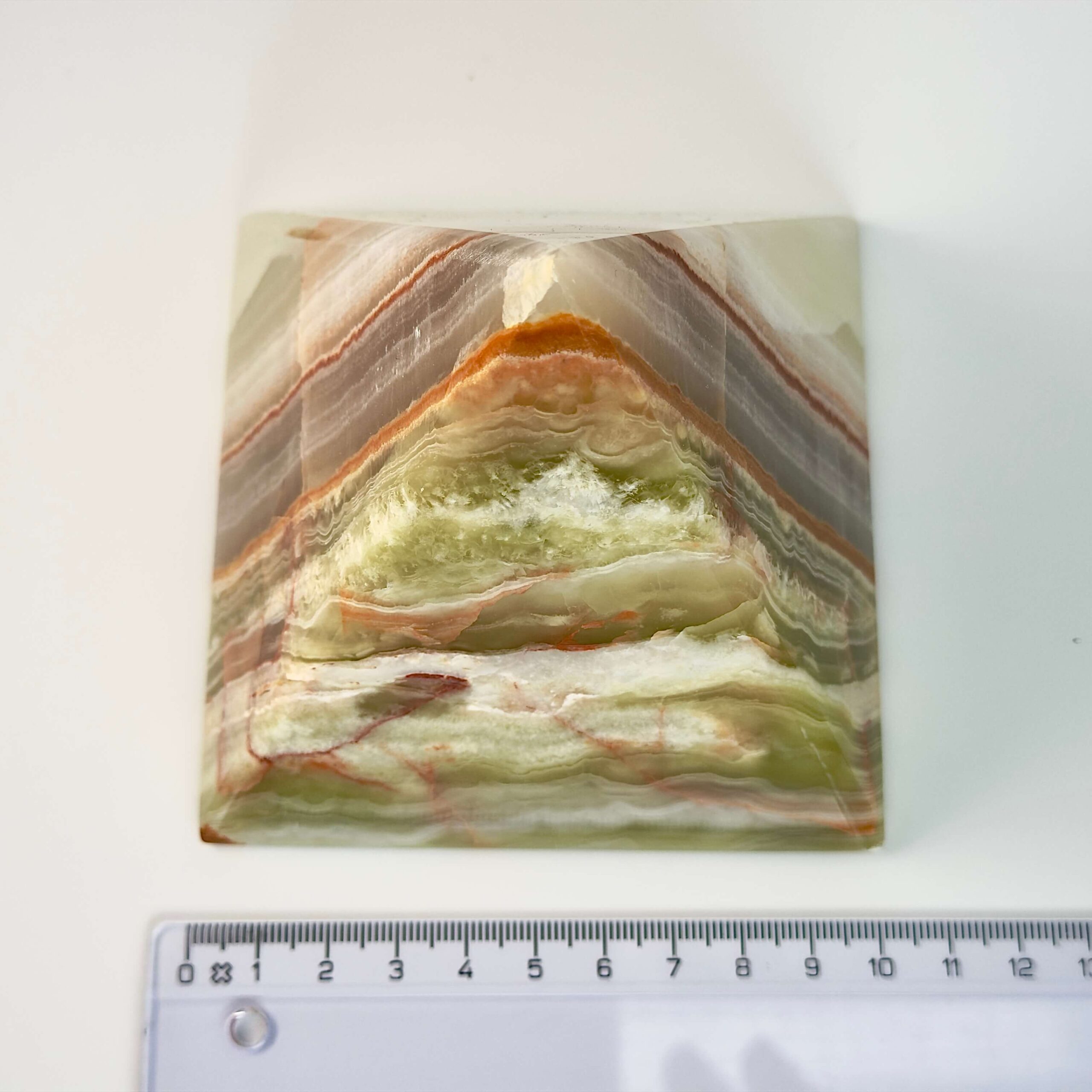 Pakistani Onyx Pyramide krystal sten med lineal på hvid baggrund