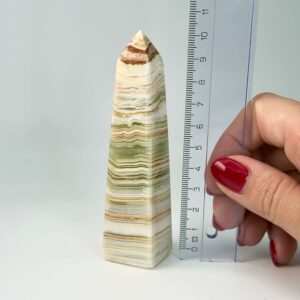 Pakistani Onyx Tårn krystal sten i hånd med lineal på hvid baggrund