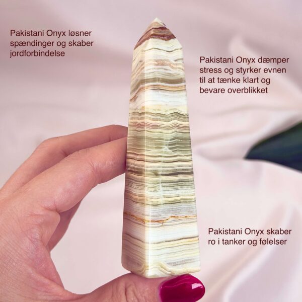 Pakistani Onyx Tårn krystal sten i hånd på hvid baggrund med tags