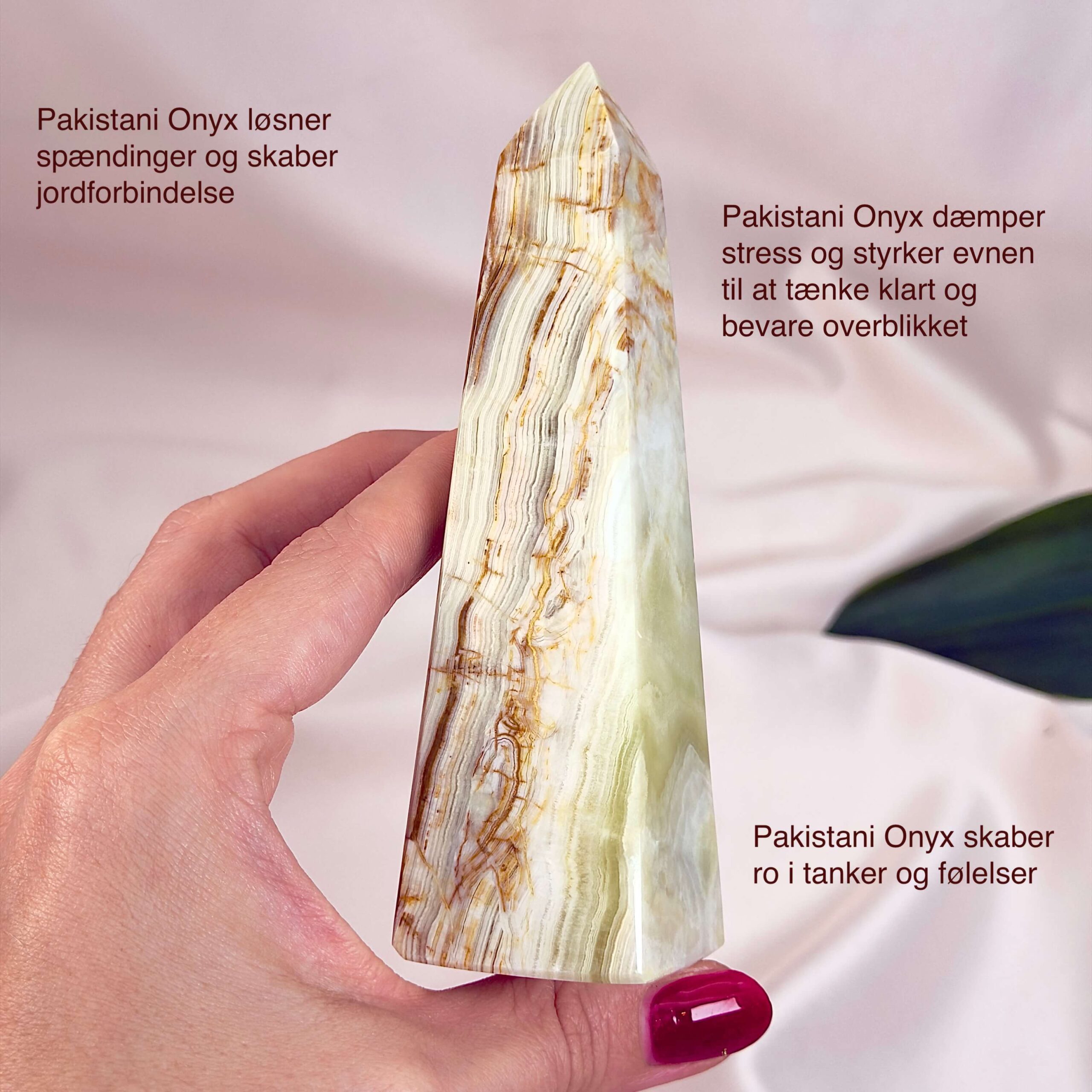 Pakistani Onyx Tårn krystal sten i hånd på hvid baggrund med tags