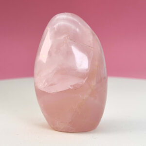 Rosakvarts Freeform Krystal Sten på hvid og lyserød baggrund