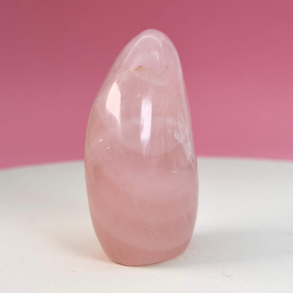 Rosakvarts Freeform Krystal Sten på hvid og lyserød baggrund
