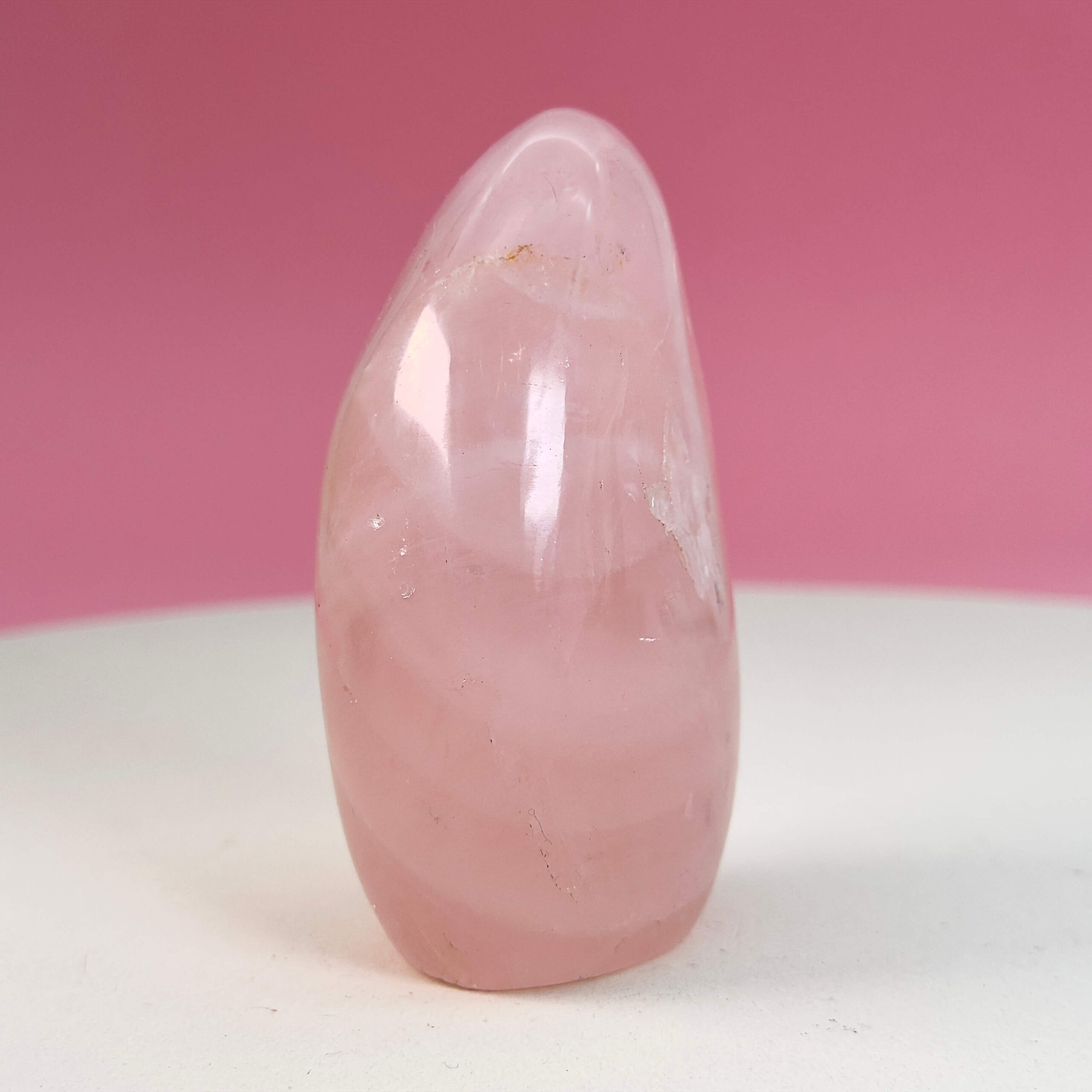 Rosakvarts Freeform Krystal Sten på hvid og lyserød baggrund