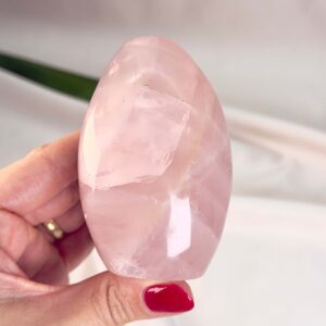 Rosakvarts Freeform Krystal Sten i hånd på hvid baggrund