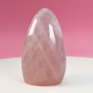 Rosakvarts Freeform Krystal Sten på hvid og lyserød baggrund