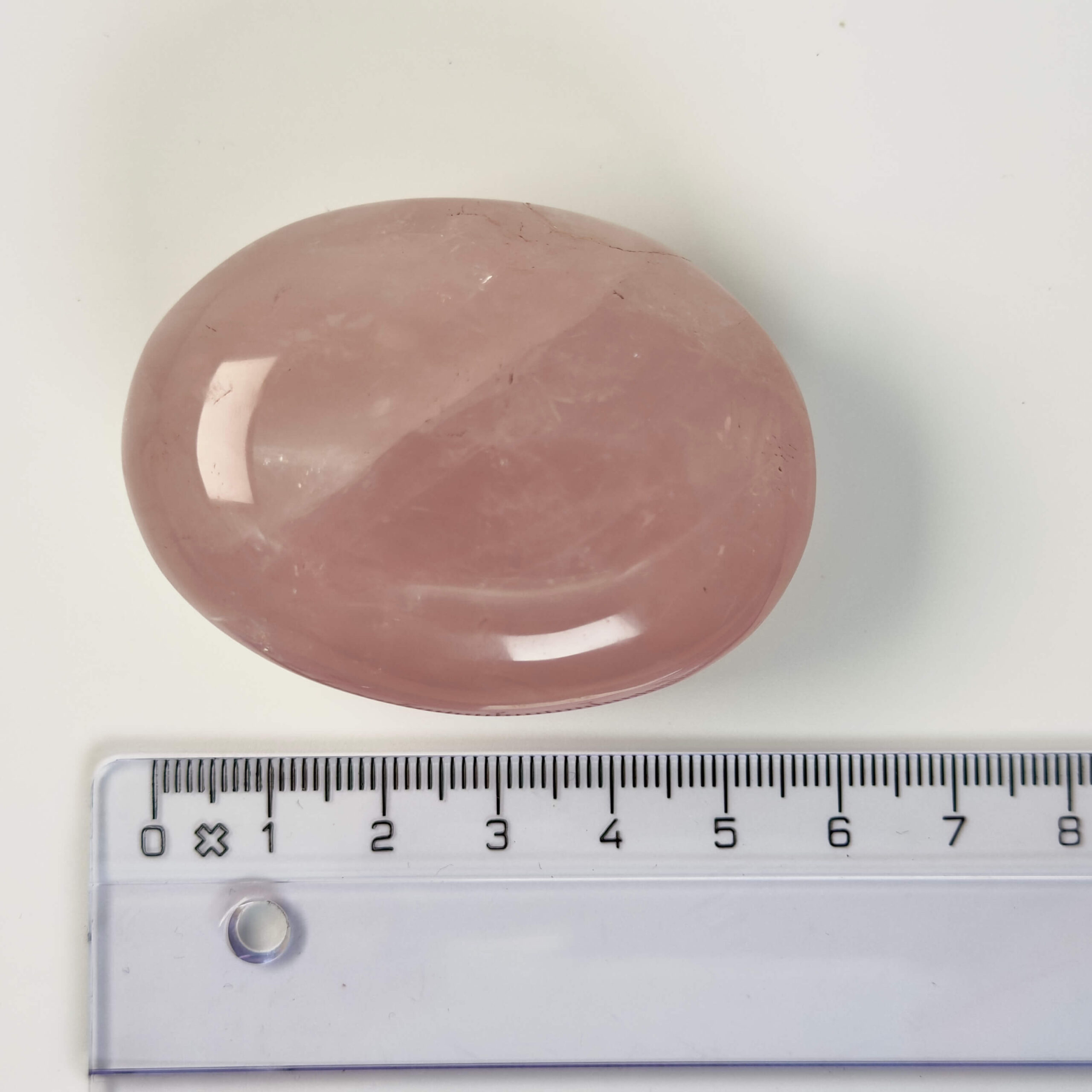 Rosakvarts Håndsten Krystal Sten med lineal på hvid baggrund