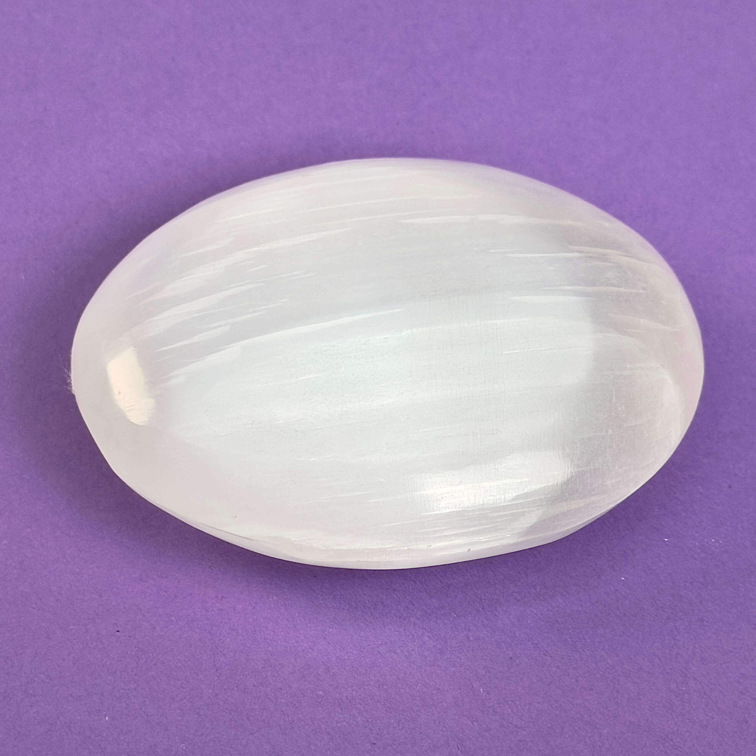 Selenit Håndsten Krystal Sten på lilla baggrund