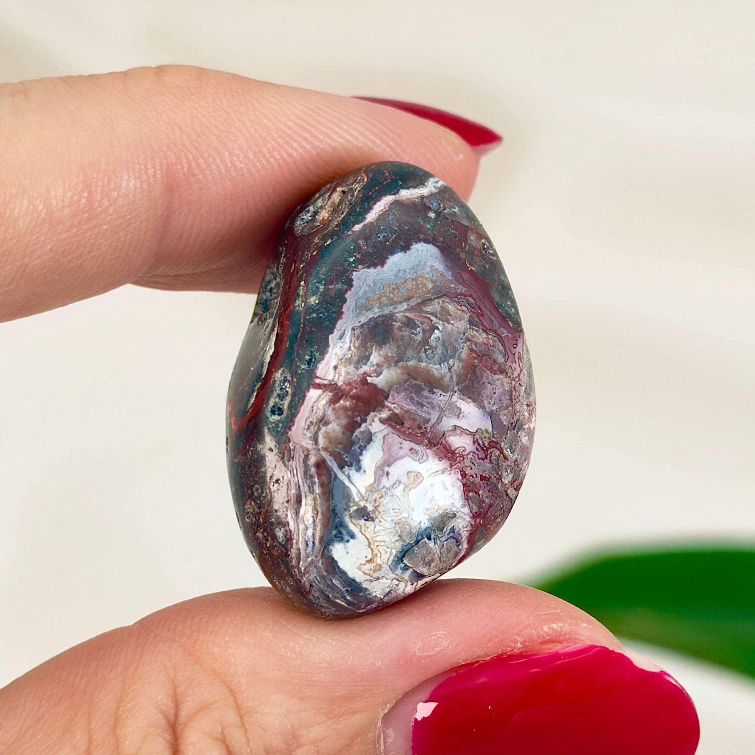 Agat Crazy Lace Lommesten Krystal Sten i hånd på hvid baggrund