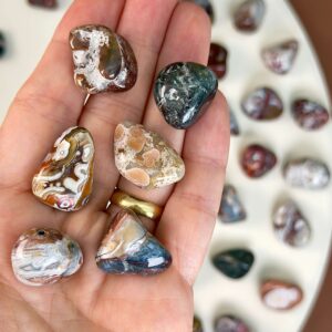 Agat Crazy Lace Lommesten Krystal Sten i hånd på hvid baggrund