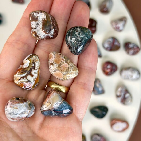 Agat Crazy Lace Lommesten Krystal Sten i hånd på hvid baggrund